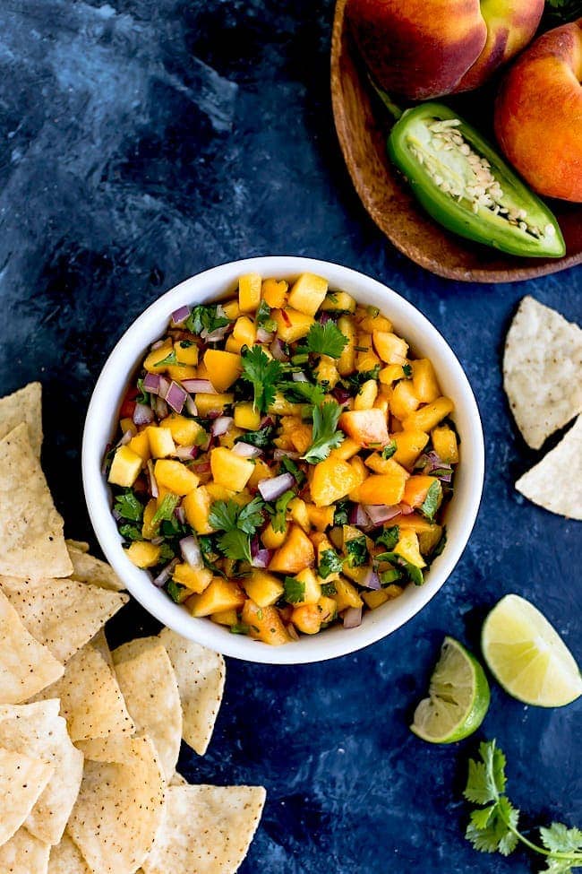 Peach Salsa Is An Easy Summer Snack That Can Be Made In Minutes. Serve The Salsa With Chips Or Use The Salsa As A Topping For Tacos, Grilled Chicken, Fish, Or Pork. This Salsa Recipe Is A Summer Favorite! #peach #salsa #easyrecipe #glutenfree #vegan #vegetarian #summer #appetizer #snack Peach Salsa in a bowl with tortilla chips