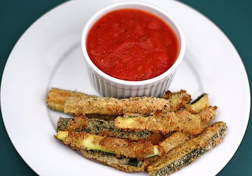 Baked zucchini fries on plate with marinara dipping sauce