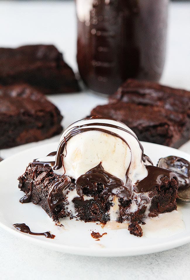The BEST brownie recipe! Almost as easy as boxed brownies but SO much better! The brownies are fudgy, rich, and full of chocolate! Top a warm brownie with ice cream and hot fudge for an extra special dessert! #brownies #dessert #baking #chocolate #brownierecipe #easyrecipe #homemade Brownie with ice cream and hot fudge on plate