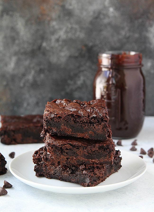stack of fudgy brownies on plate.