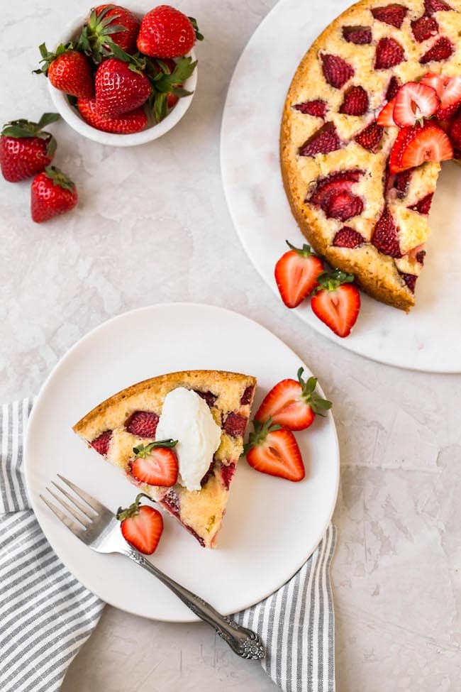 strawberry cake with whipped cream on plate with fork. 