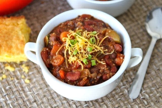 bowl of vegan chili garnished with cheese and scallions