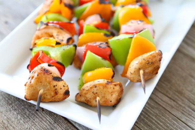 Three chicken kabobs with peppers served on platter