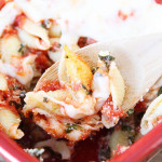 Baked pasta shells on wooden spoon