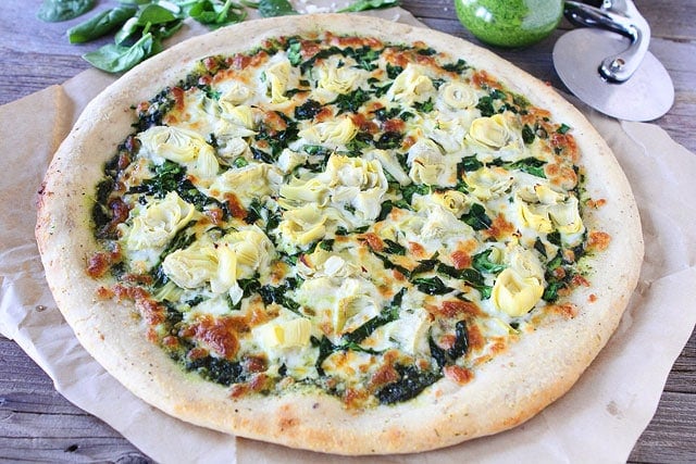 Spinach Artichoke Pesto Pizza Recipe on twopeasandtheirpod.com A fresh and simple pizza!