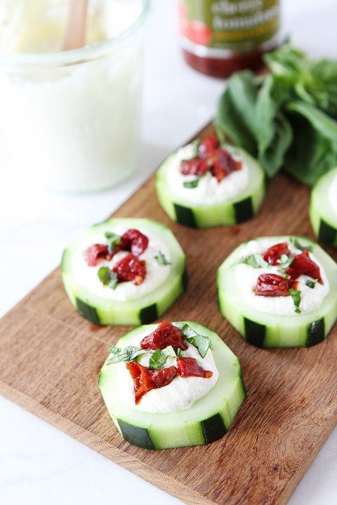 Cucumber Canapés with Whipped Feta, Sun-Dried Tomatoes and Basil on twopeasandtheirpod.com