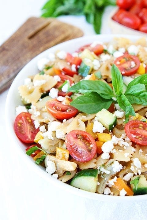Summer Pasta Salad with veggies in a bowl garnished with basil. 
