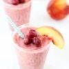 Peach smoothie with raspberries in glass