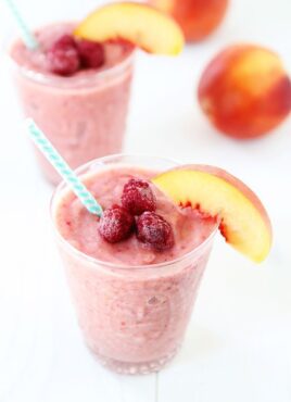 Peach smoothie with raspberries in glass