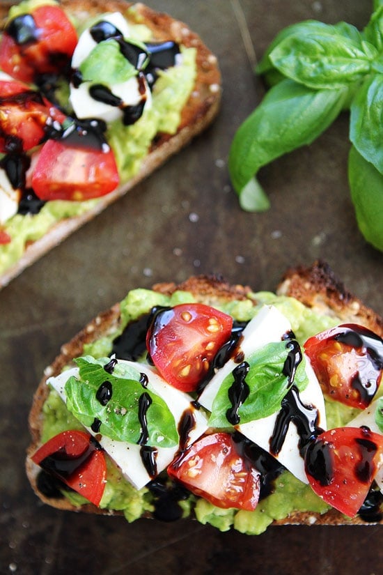 Caprese Avocado Toast Recipe on twopeasandtheirpod.com Caprese salad meets avocado toast! This is the BEST avocado toast and it's good anytime of the day! Caprese Avocado Toast