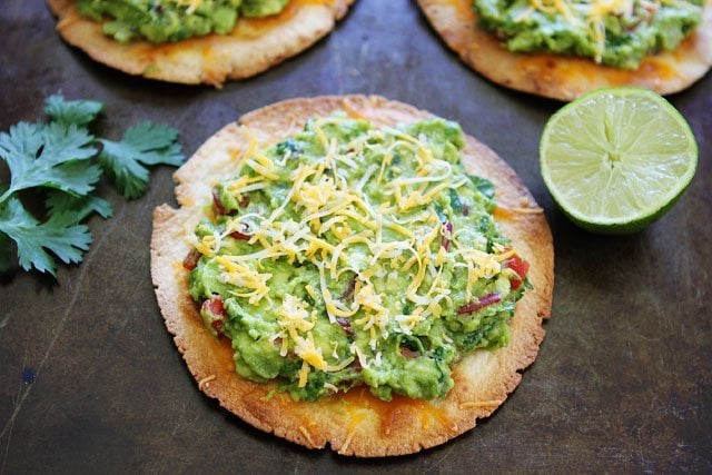 Tostada smothered in guacamole and topped with cheese