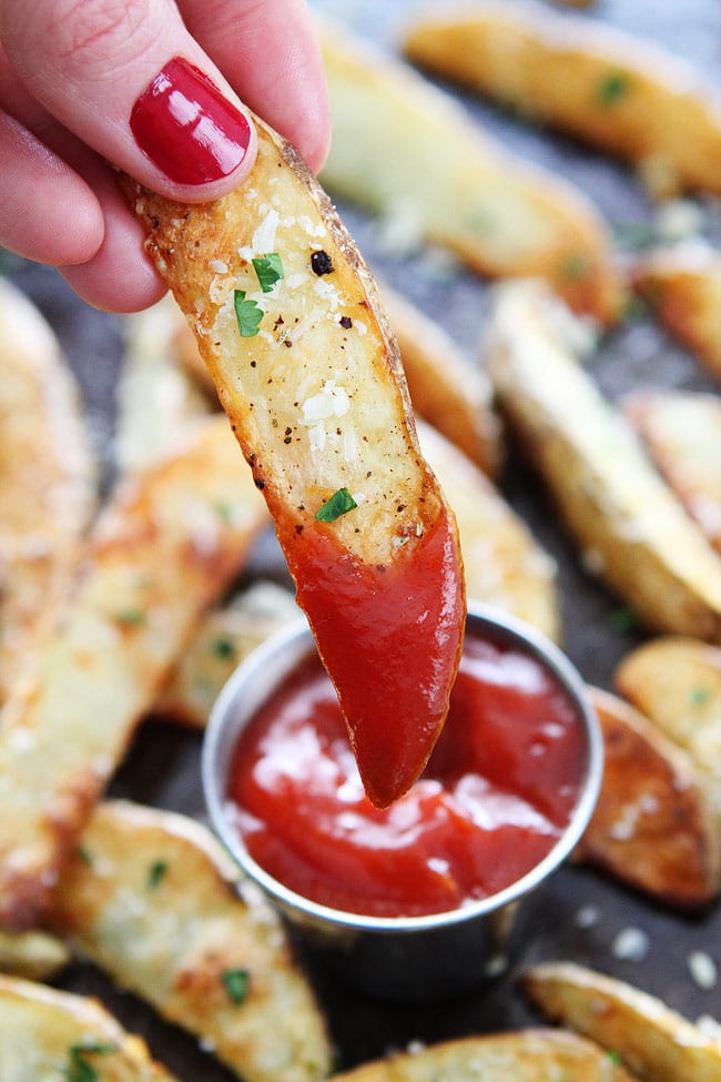 Parmesan Potato Wedges dipped in ketchup