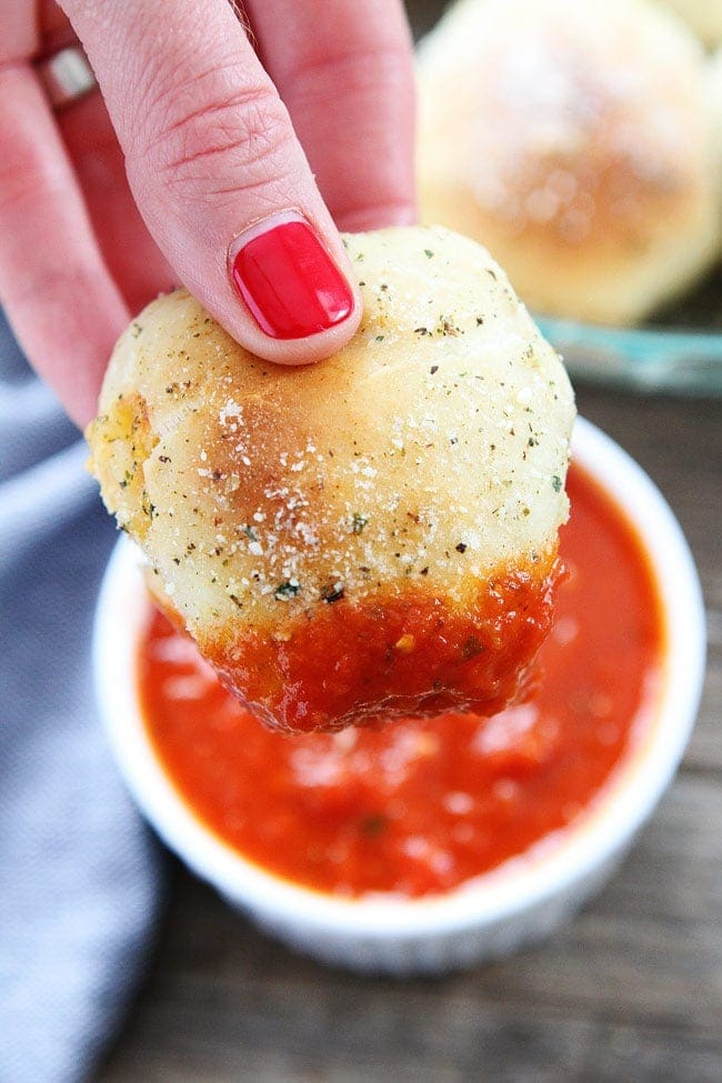 dipping homemade pizza rolls in marinara 