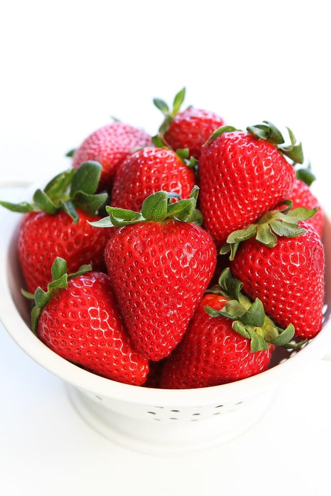 Colander of fresh strawberries to add in caprese salad
