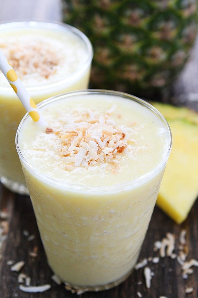 Pineapple Coconut Smoothie in glass with toasted coconut on top