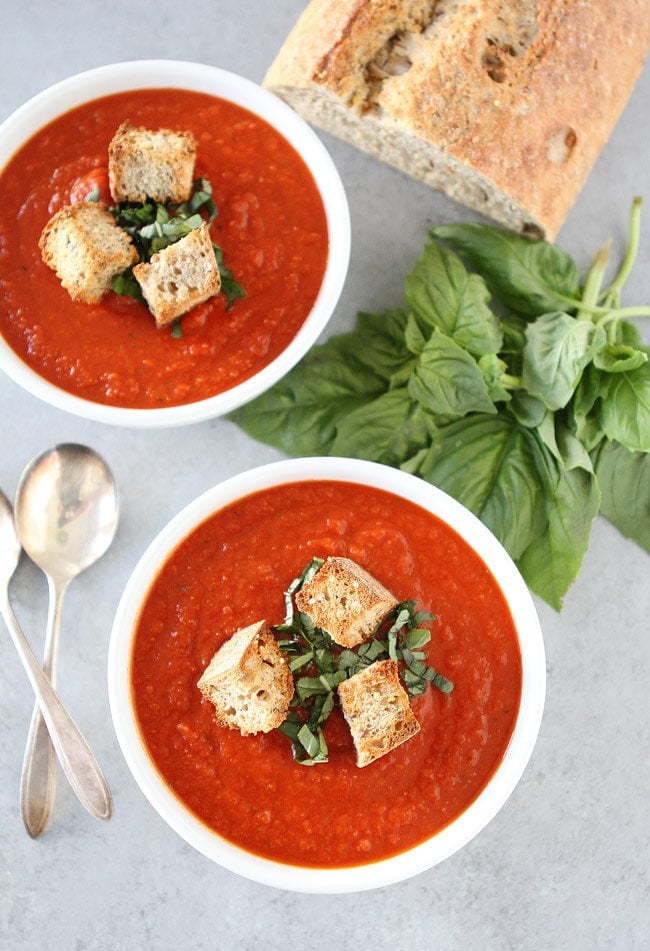 Roasted Red Pepper Tomato Soup in bowls with croutons and fresh basil. 