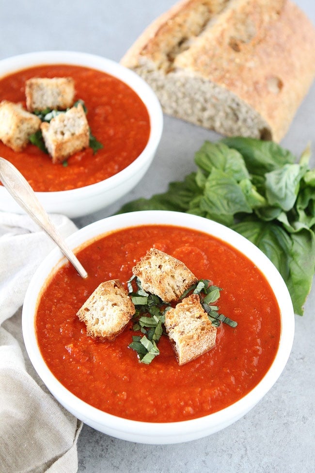 Roasted Red Pepper Tomato Soup Recipe in white bowls with croutons and basil. 