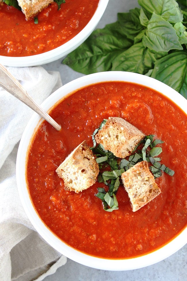 Roasted Red Pepper Tomato Soup  in bowl with spoon. 