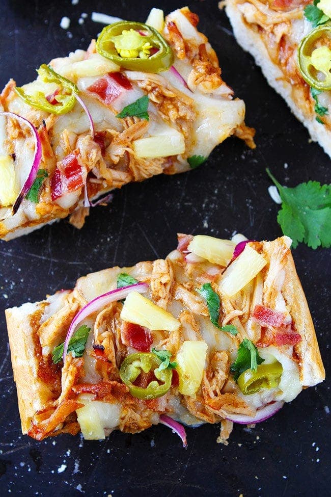 BBQ Chicken French Bread Pizza made with store-bought French bread and topped with BBQ sauce, chicken, bacon, mozzarella cheese, pineapple, jalapeño, and cilantro. This easy pizza is a favorite weeknight meal.