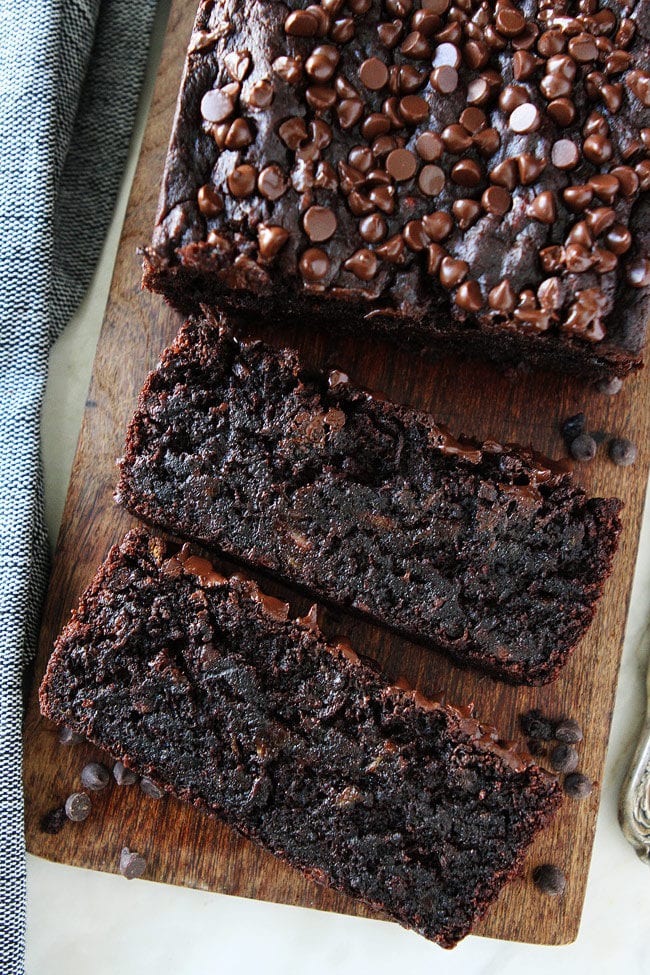 Gluten-Free Vegan Chocolate Banana Bread Recipe on twopeasandtheirpod.com You will never know this chocolate banana bread is gluten-free and vegan. It is SO rich, moist, and delicious! It is bread but tastes more like cake! WIN! Chocolate Vegan Banana Bread sliced on cutting board