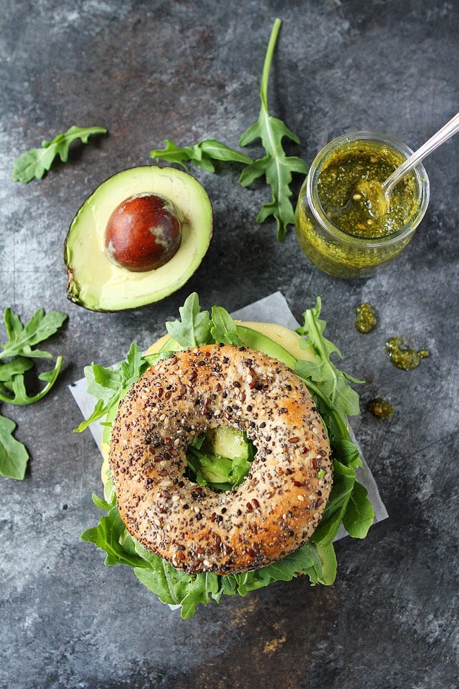 Egg, Avocado, and Pesto Bagel Sandwich with arugula. 