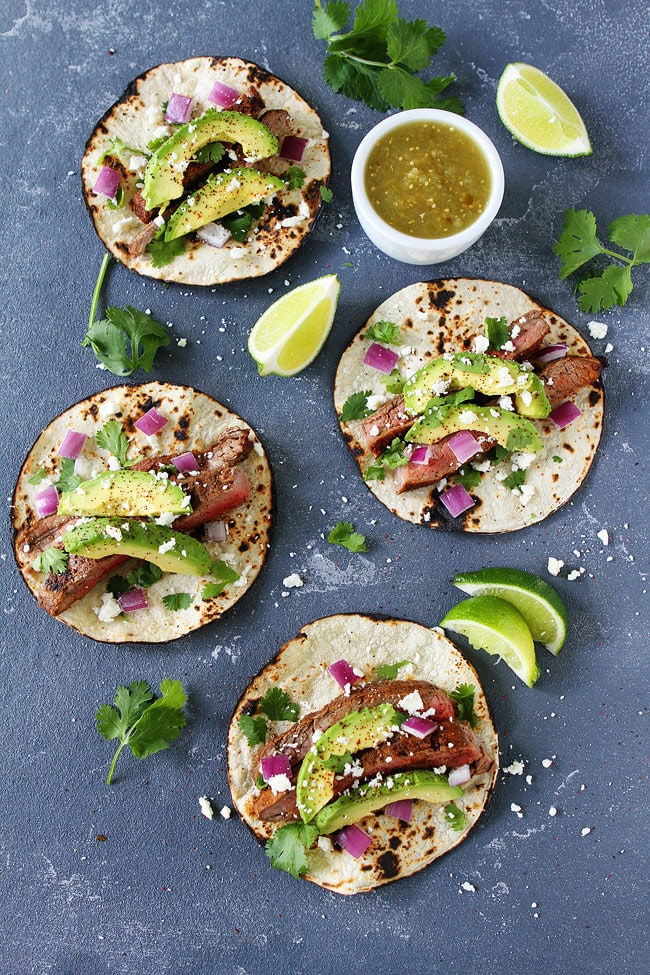 Steak Tacos with red onion, avocado, cilantro, and queso fresco.