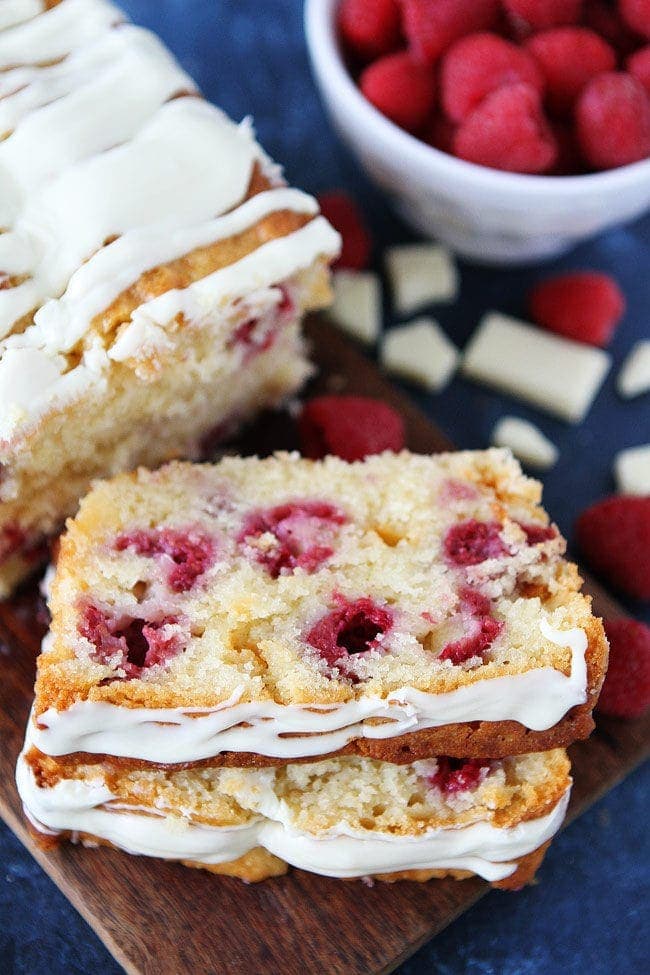 Raspberry White Chocolate Loaf Cake with fresh raspberries, white chocolate chunks, and white chocolate glaze