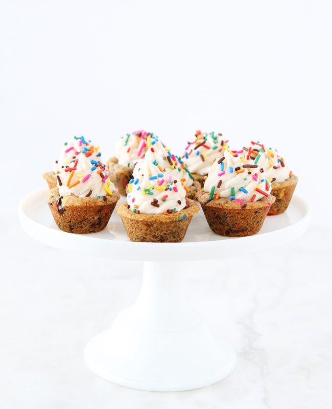 Sprinkle Chocolate Chip Cookie Cups topped with frosting are a fun dessert for any celebration. Kids and adults love these easy cookie cups!