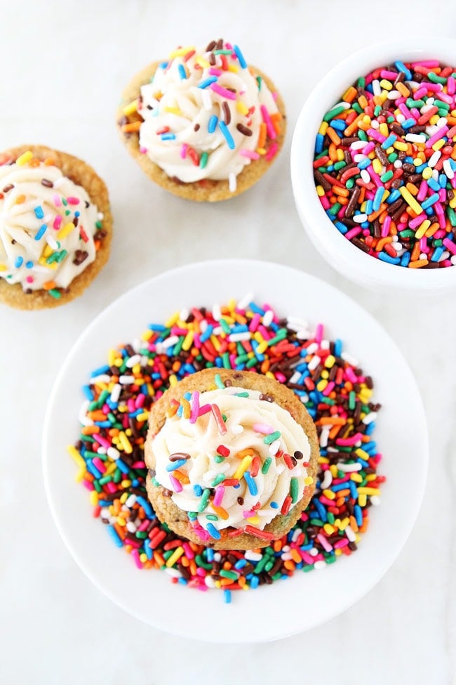 Sprinkle Chocolate Chip Cookie Cups topped with frosting are a fun and delicious dessert! They are perfect for parties and potlucks!