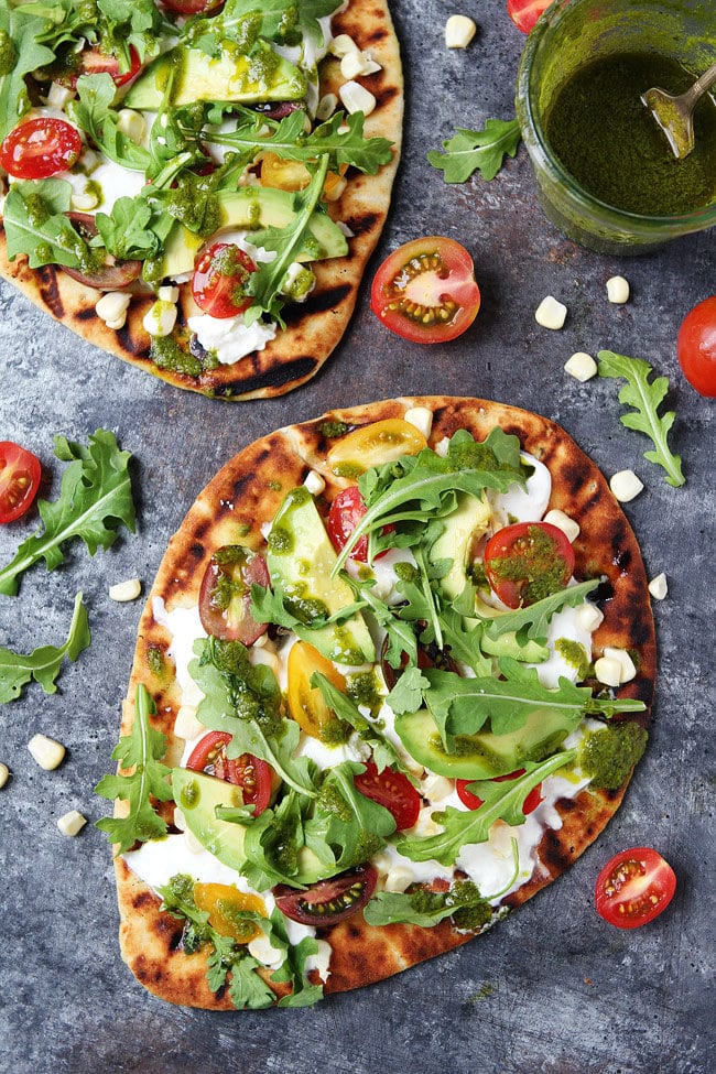Tomato, Avocado, and Burrata Flatbread-grilled flatbread topped with burrata cheese, tomatoes, avocado, corn, and basil vinaigrette. This easy grilled flatbread pizza is a summer favorite! 