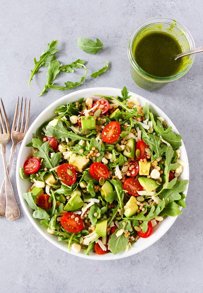 Summer Arugula Salad with couscous, avocado, corn, tomatoes, cheese, pepitas, and a simple basil vinaigrette. This fresh and healthy salad goes great with any summer meal or can be your summer meal!