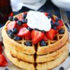 Belgian Waffles stacked with strawberries, blueberries and cream