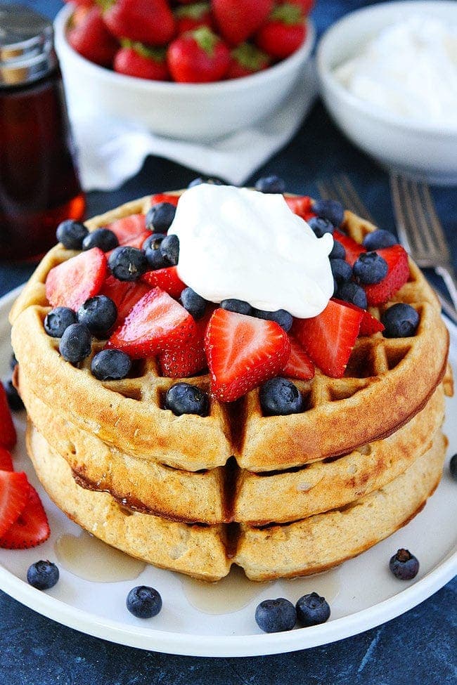 Belgian Waffles stacked with strawberries, blueberries and cream.