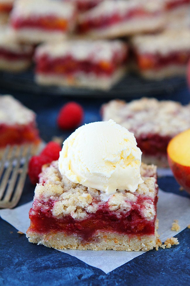 Peach Raspberry Crumb Bars topped with vanilla ice cream