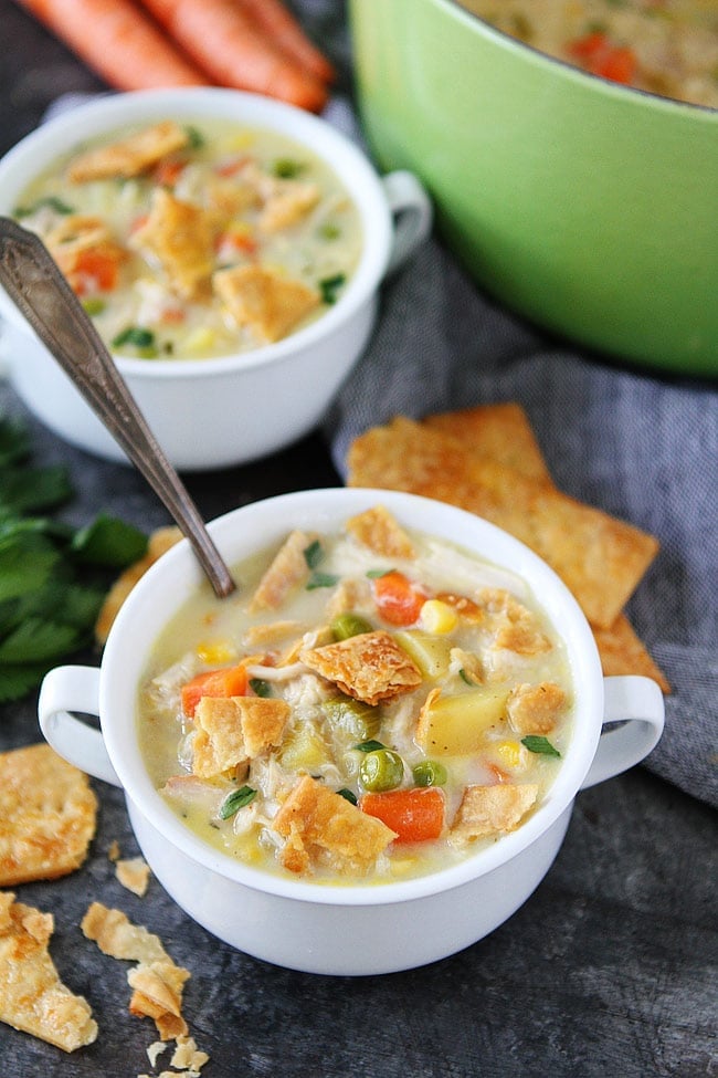 chicken pot pie soup in bowl with spoon and pie crust crackers. 