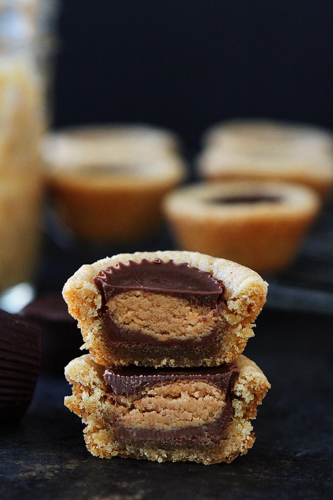 peanut butter cookie cut in half stacked on top of each other showing the peanut butter cup. 