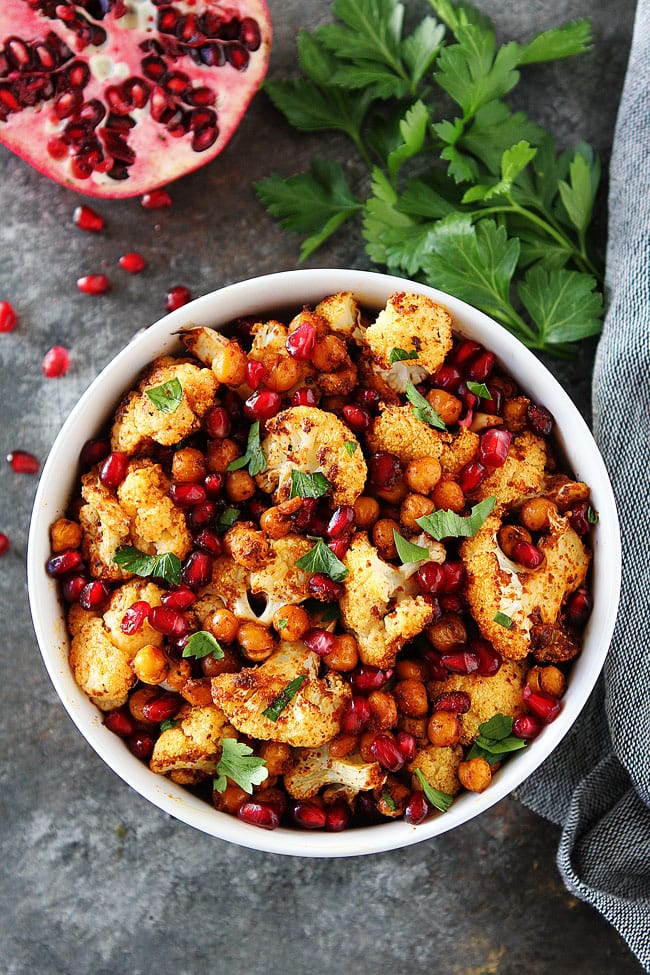 Roasted Cauliflower with Chickpeas and Pomegranate-this easy, healthy side dish is perfect for Thanksgiving and Christmas. It is easy to make, pretty to serve, and delicious to eat! #holidays #vegan #glutenfree #cauliflower #sidedish #chickpeas
