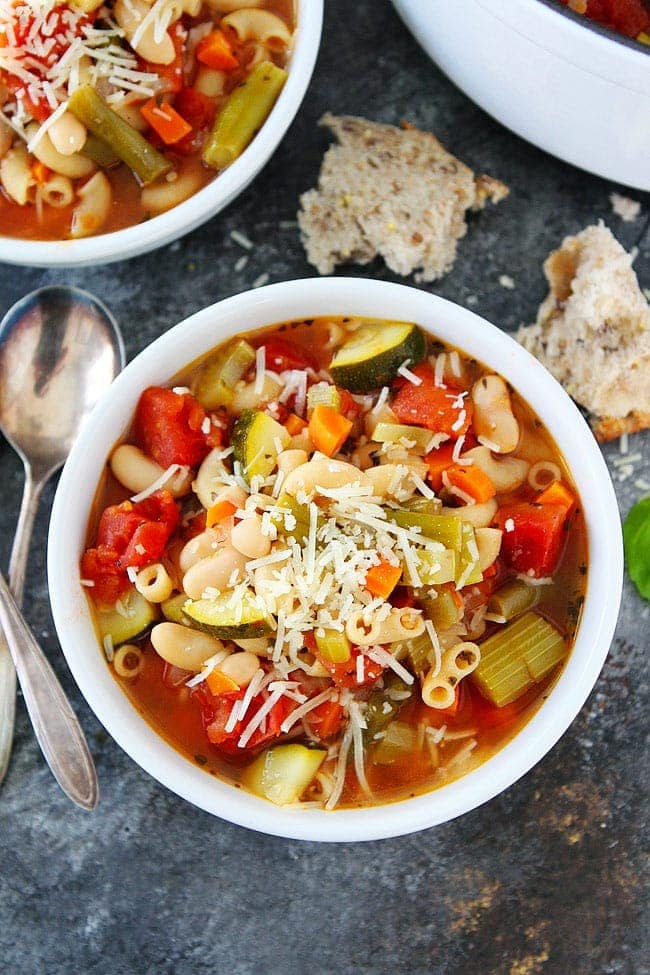 Easy Minestrone Soup Recipe-this healthy vegetarian soup is perfect for a cold day! #soup #minestrone #easyrecipes #dinner Minestrone Soup with vegetables, beans, and Parmesan cheese in bowl.