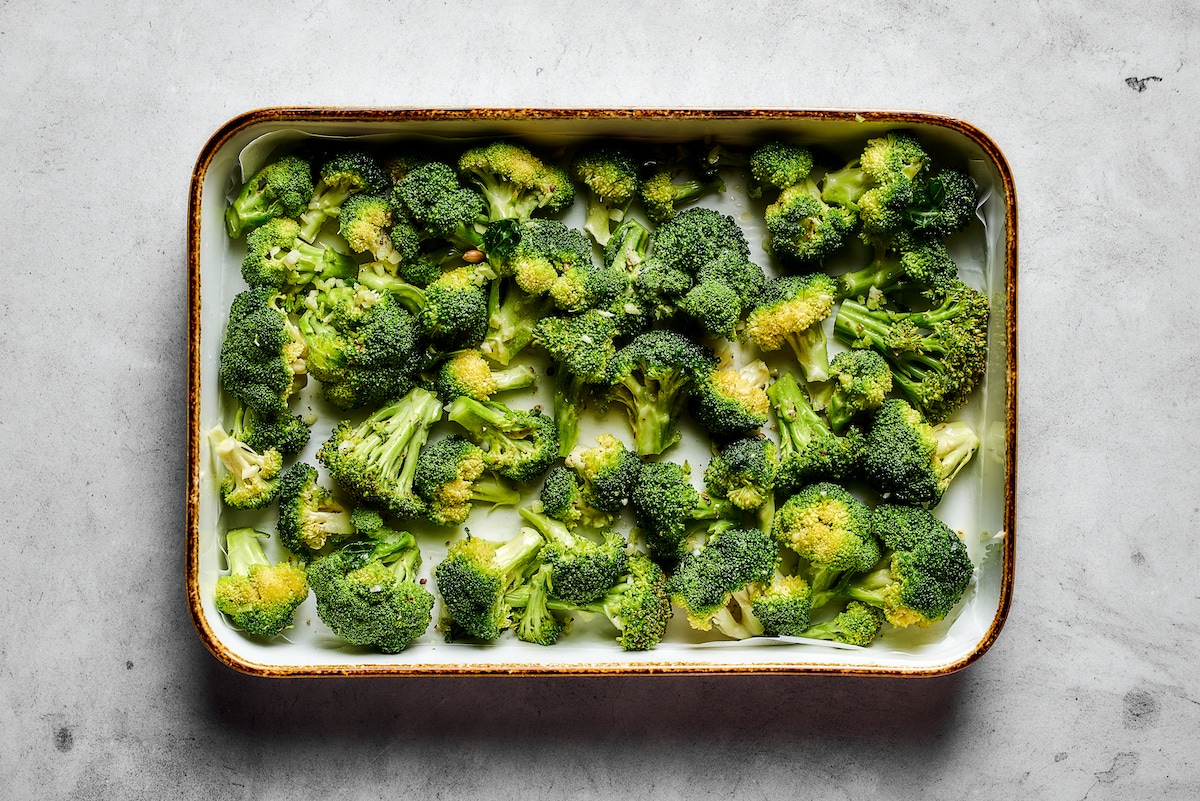 Broccoli florets on a metal baking sheet.