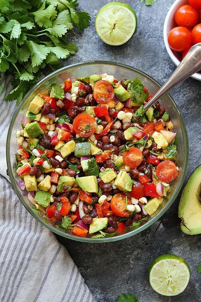 Black Bean Salad in glass bowl with spoon. 