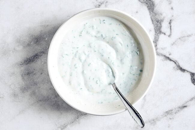 A bowl of lime crema with a spoon in it