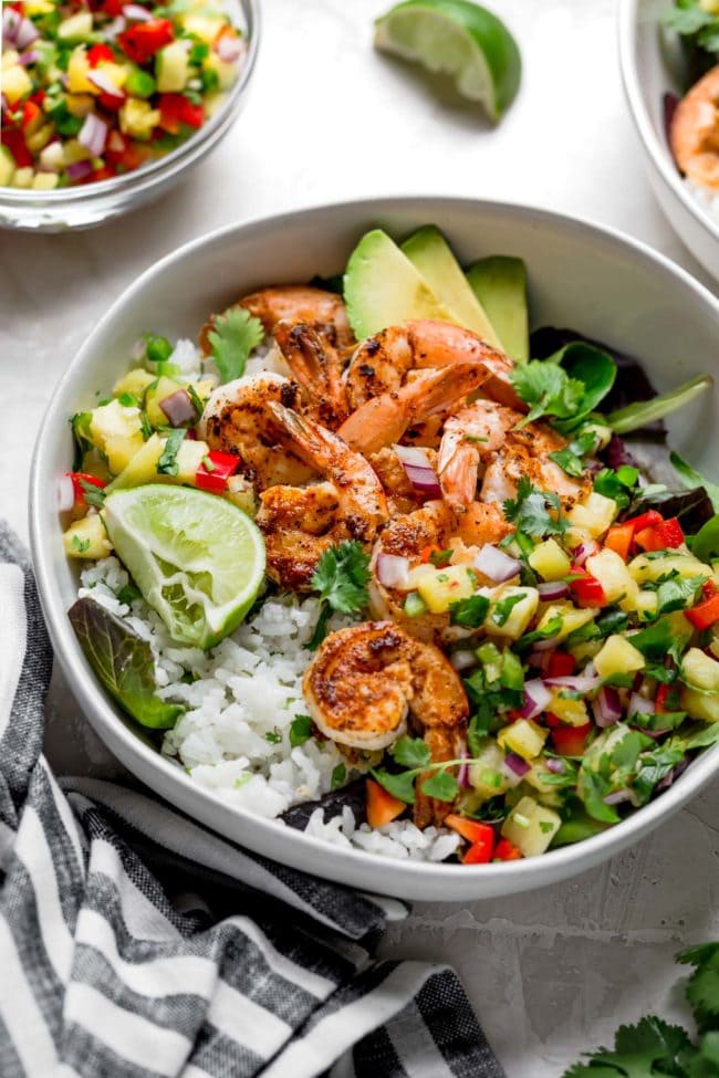 Shrimp bowl with coconut lime rice, fresh pineapple salsa, avocado, and lime. 