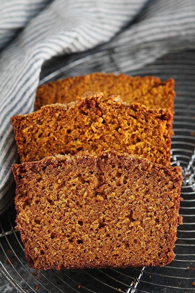 pumpkin bread slices on cooling rack with towel. 