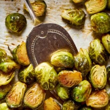 Close up of a serving spoon scooping some roasted brussels sprouts