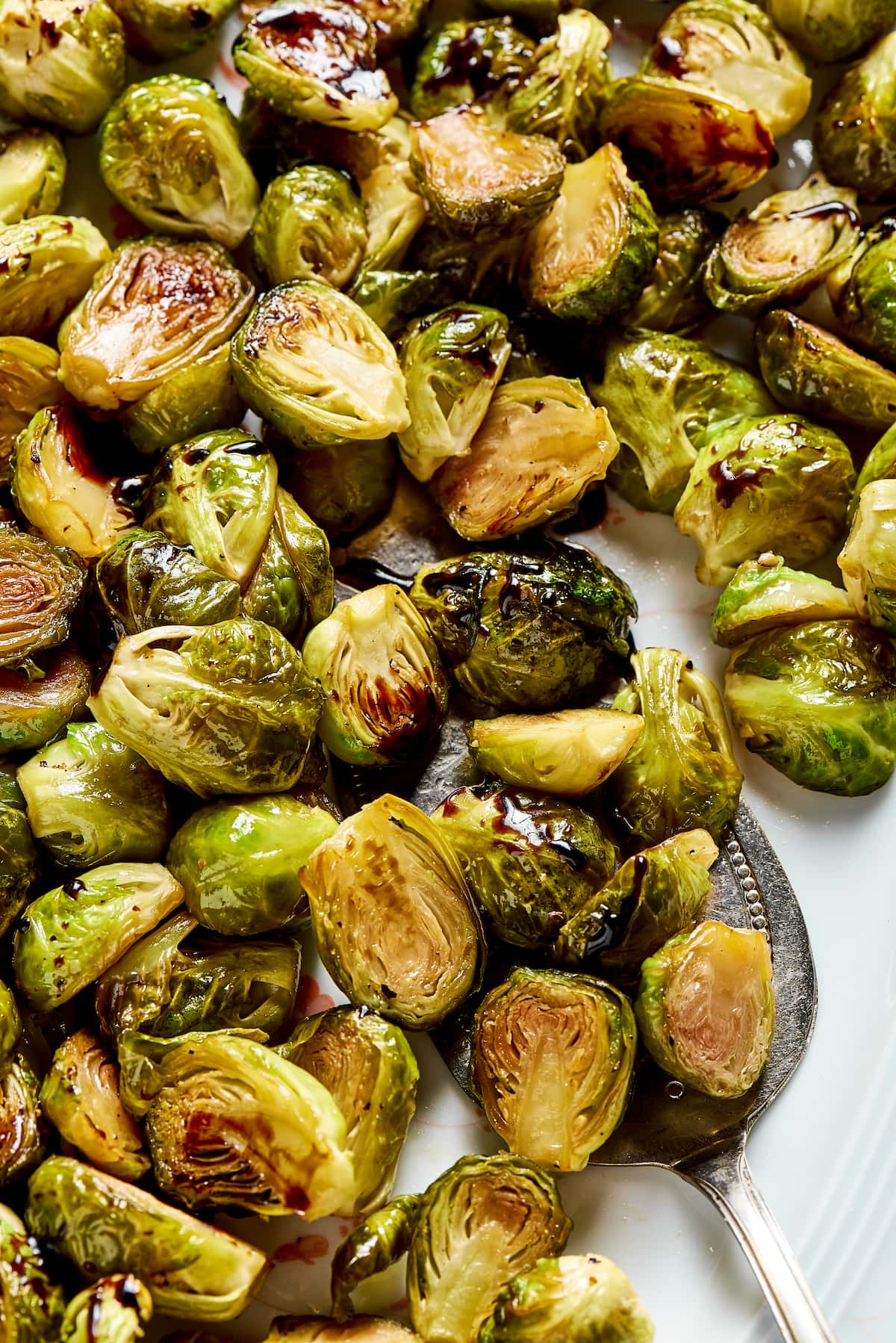 A tray of roasted Brussels sprouts, with a serving spoon in them