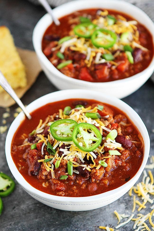 slow cooker chili in bowls with toppings. 