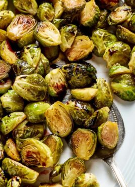 A tray of roasted brussels sprouts, with a serving spoon in them