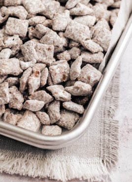 The corner of a metal pan filled with homemade puppy chow.