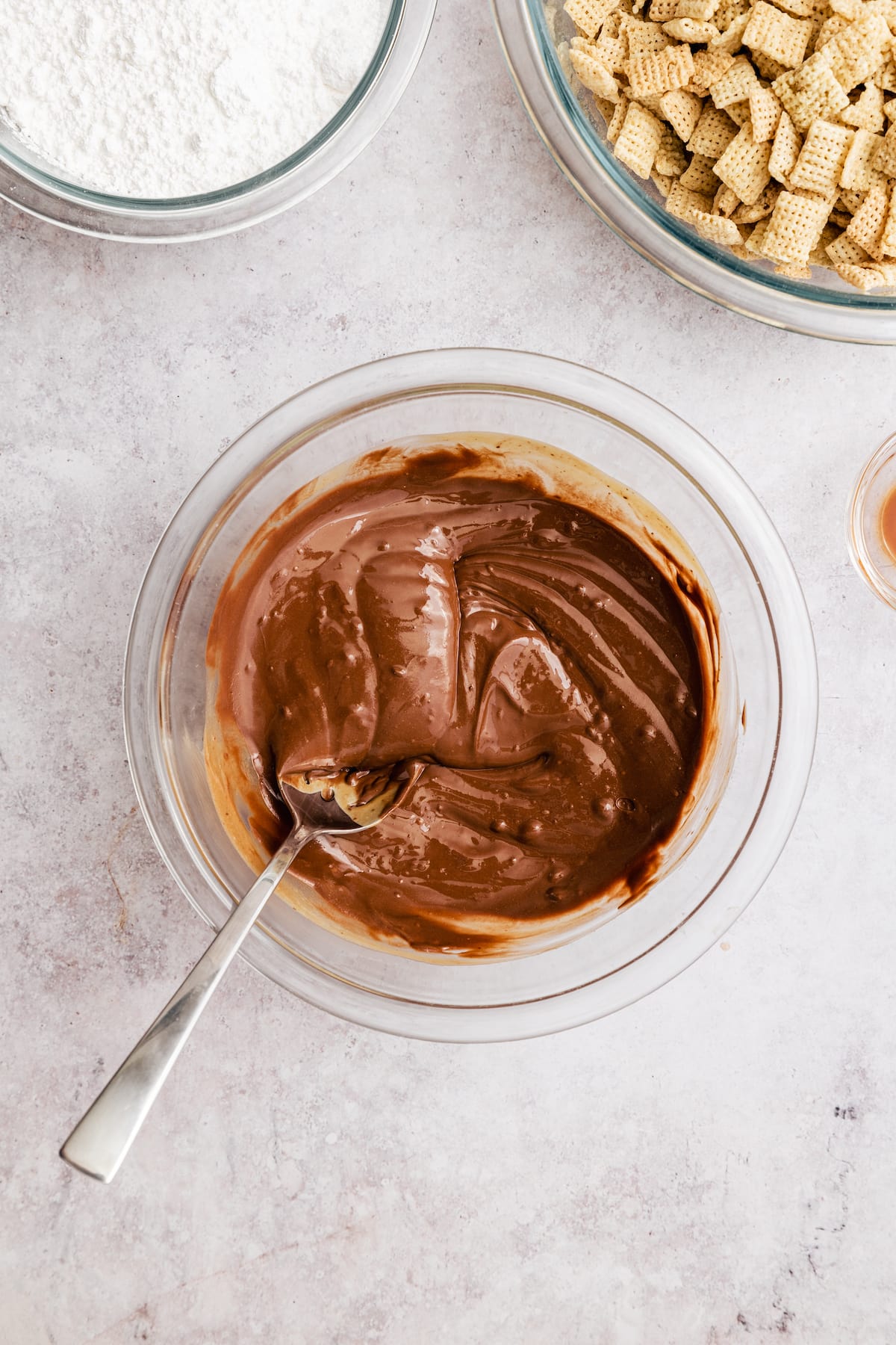 Chocolate and peanut butter melted together in a glass mixing bowl.
