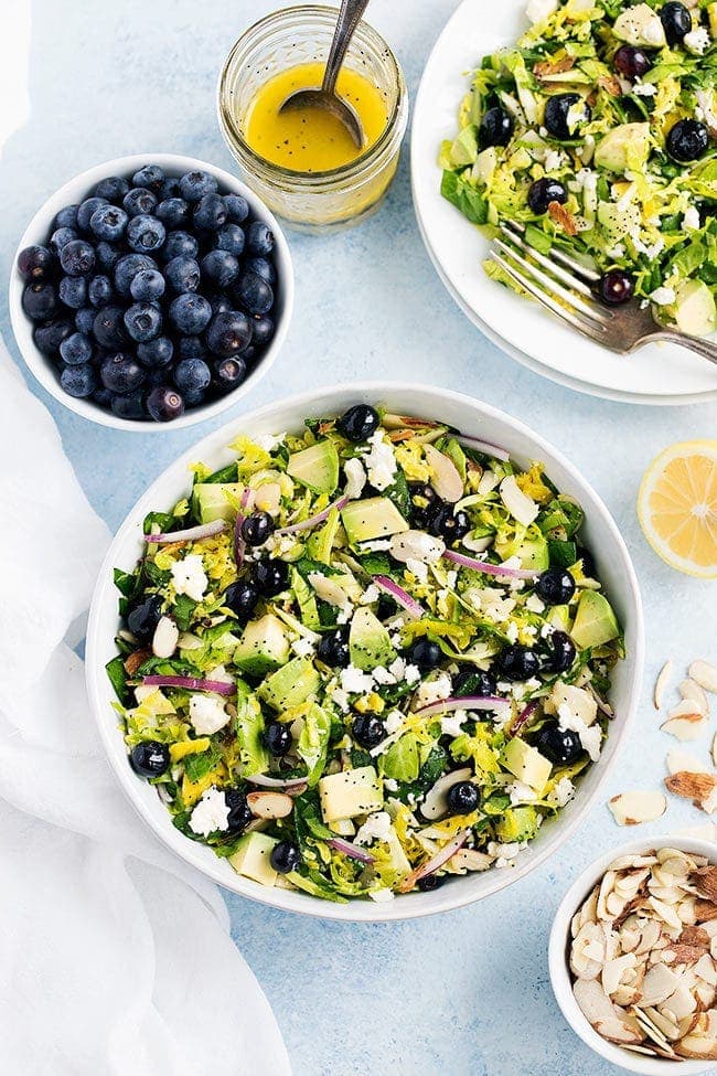 Blueberry Brussels Sprout Salad in bowl with avocado and lemon poppy seed dressing.